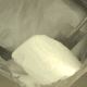 image depicting a large block of chemical powder material and shovel that was used to dislodge it
